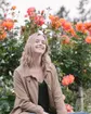 Emma sitting in a rose garden